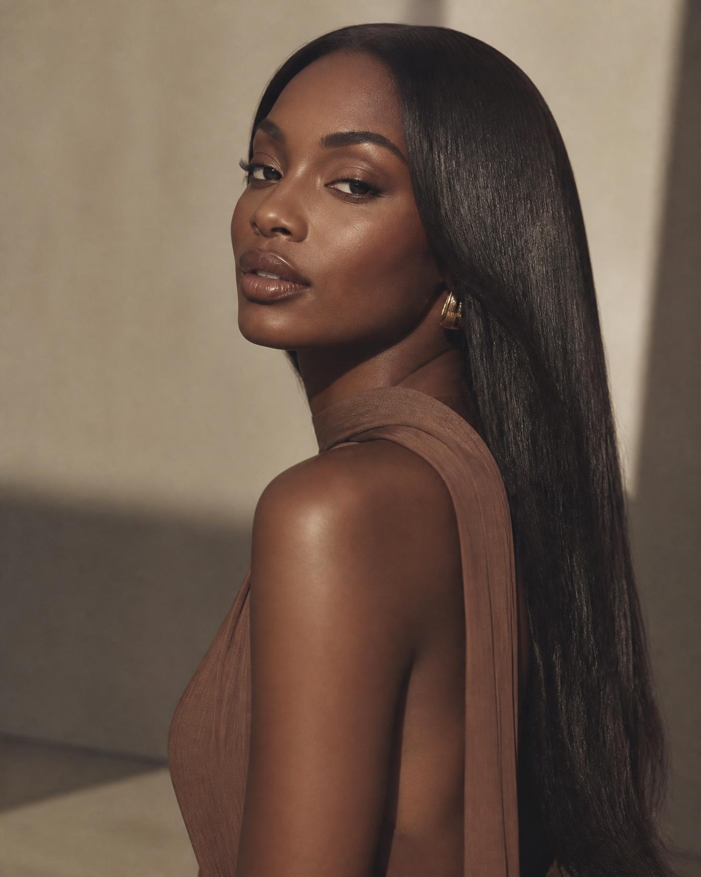 Model wearing a sleek, glossy Ice of Lagos Hair straight wig in warm studio light